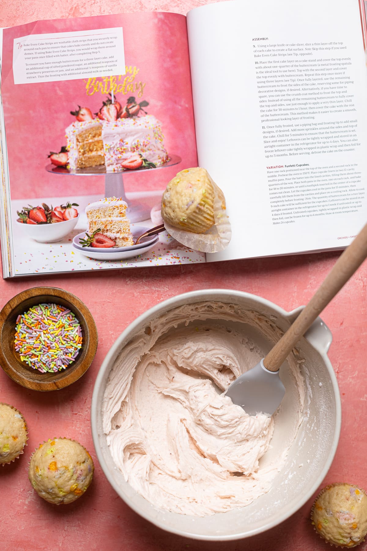 Cupcakes and a bowl of frosting next to the Orchids + Sweet Tea cookbook opened to the cake recipe