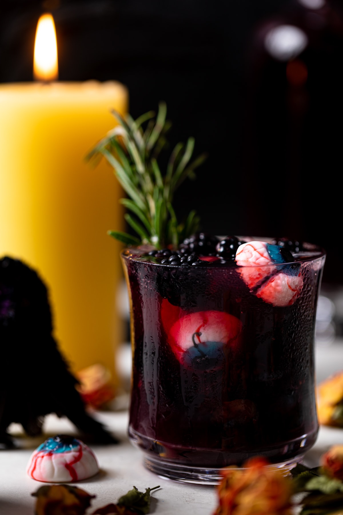 Edible eyes and blackberries floating in a dark Blueberry Blackberry Mocktail 