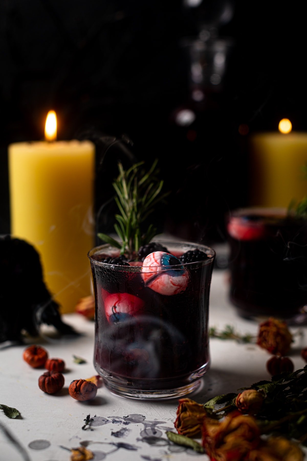 Dark Blueberry Blackberry Mocktail in a small glass with edible Halloween eyes