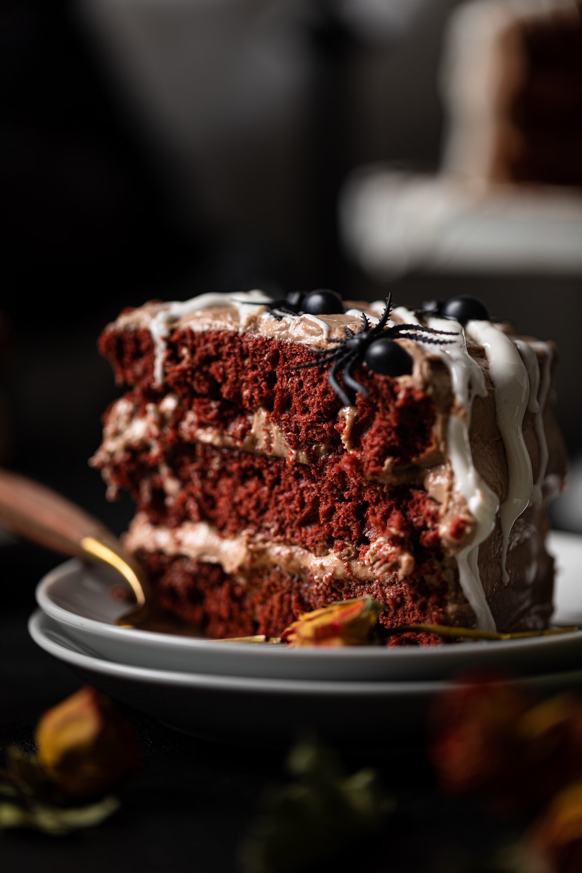 Slice of Black Widow Red Velvet Cake topped with black spiders