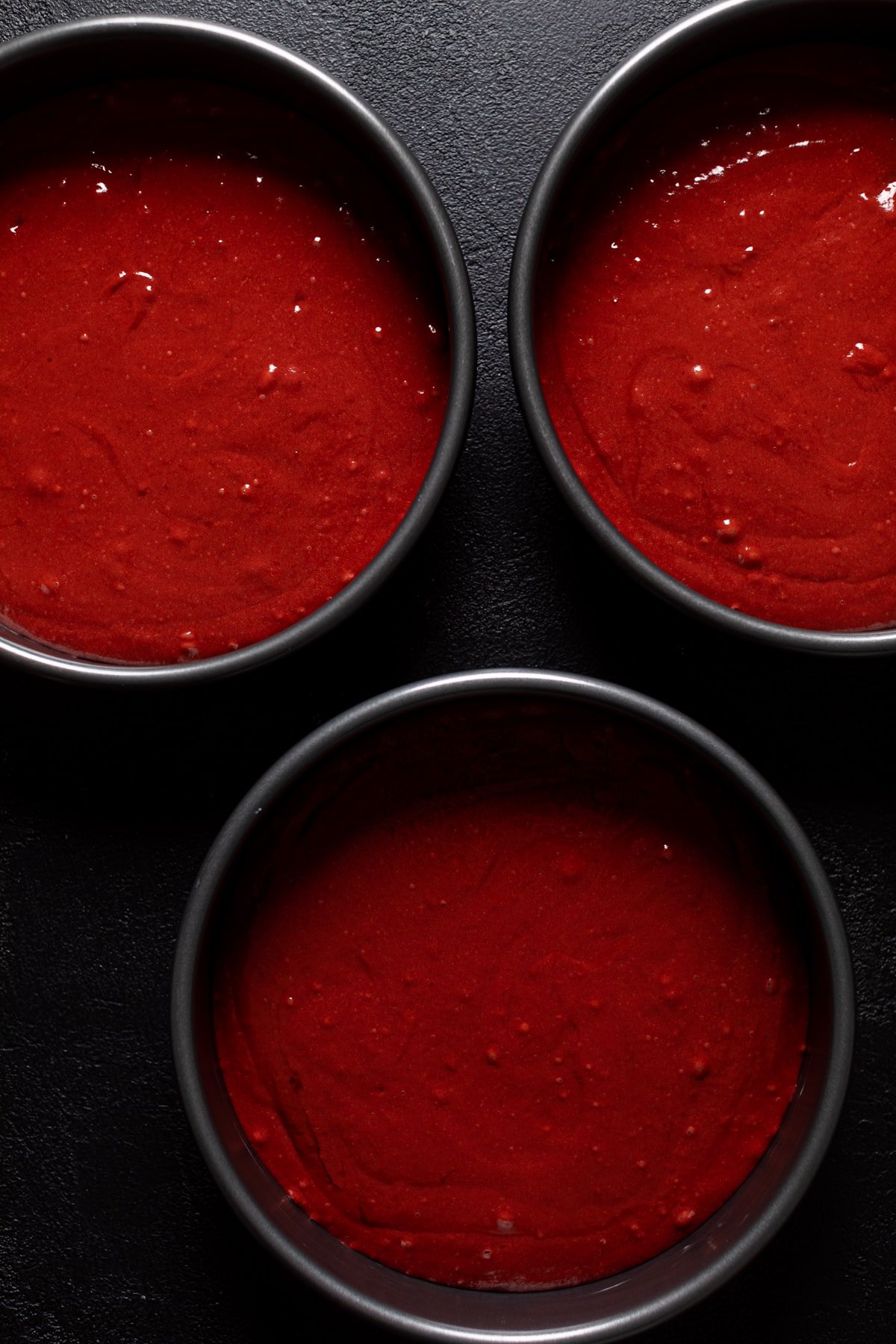 Three round pans of Black Widow Red Velvet Cake batter