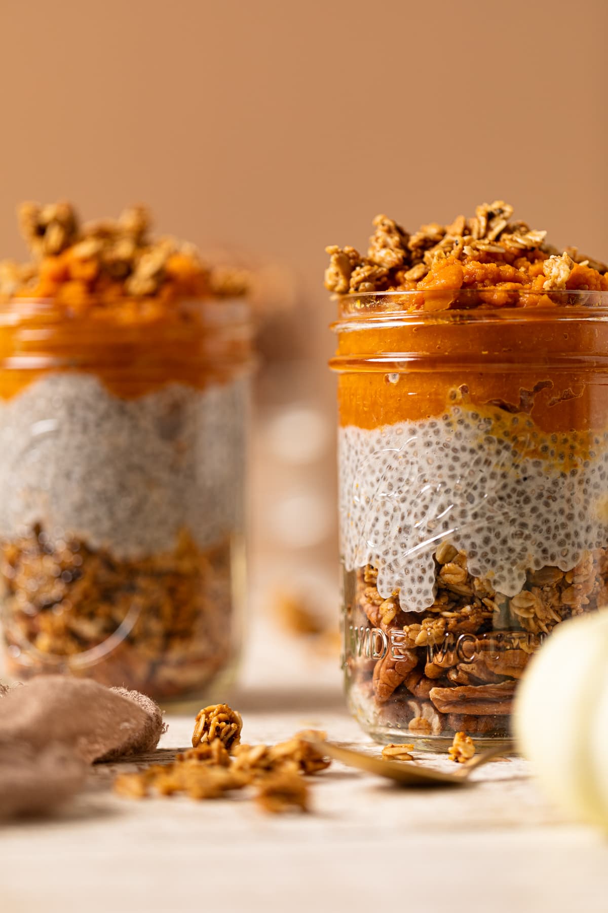 Two jars of Pumpkin Pie Chia Pudding on a white table