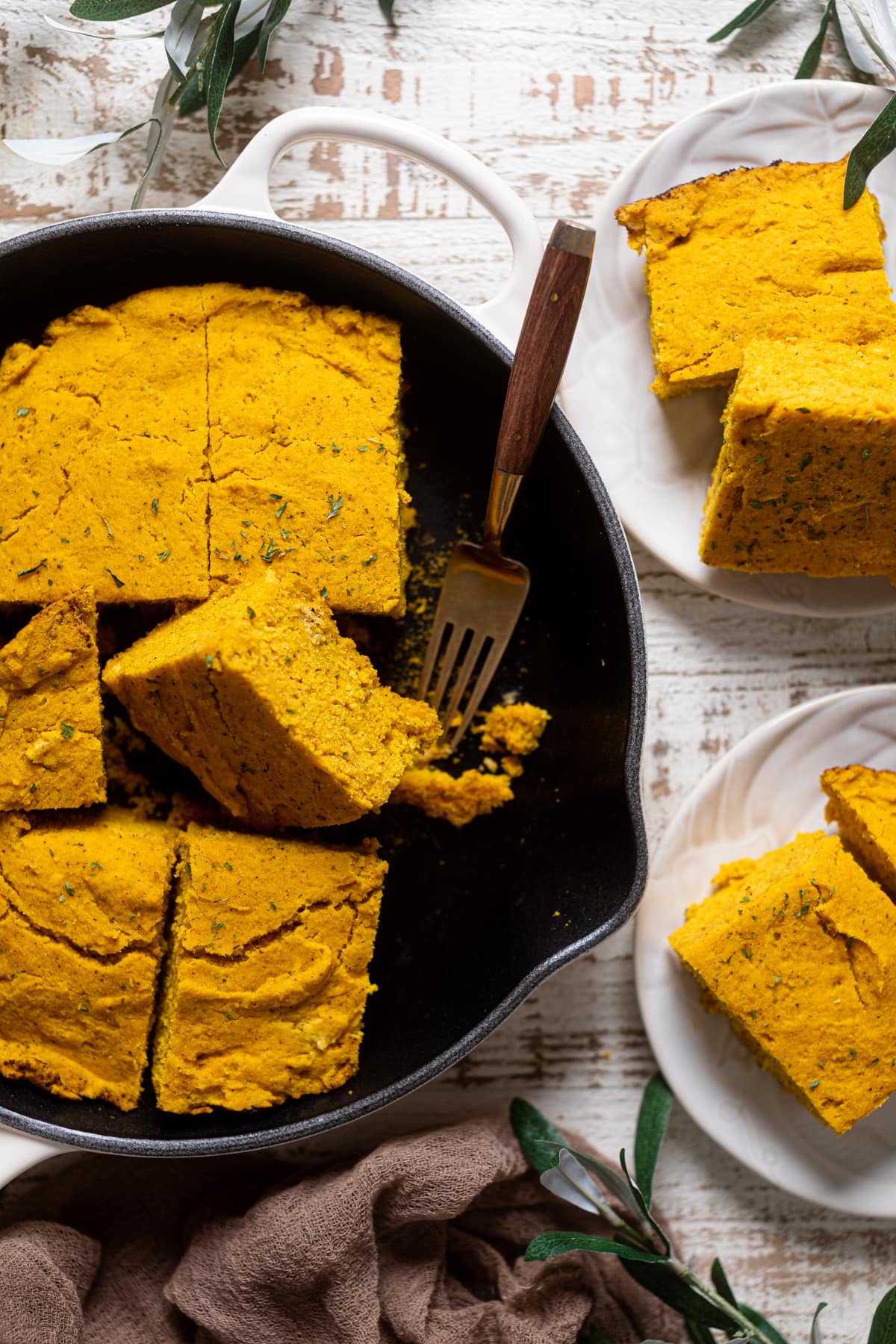 Fork in a skillet of sliced Brown Butter Pumpkin Cornbread 