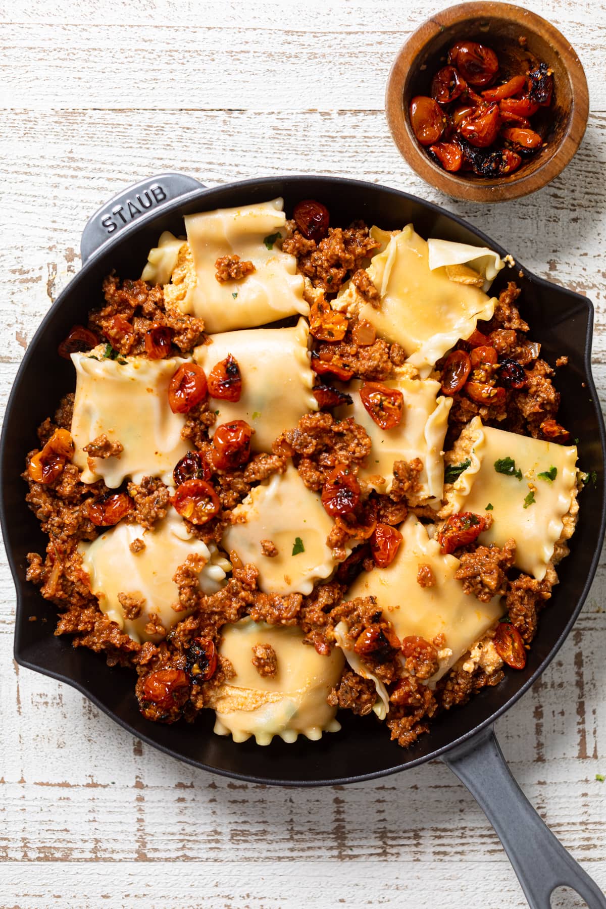 Skillet with rolled and stuffed lasagna noodles and plant-based \"meat\" mixture