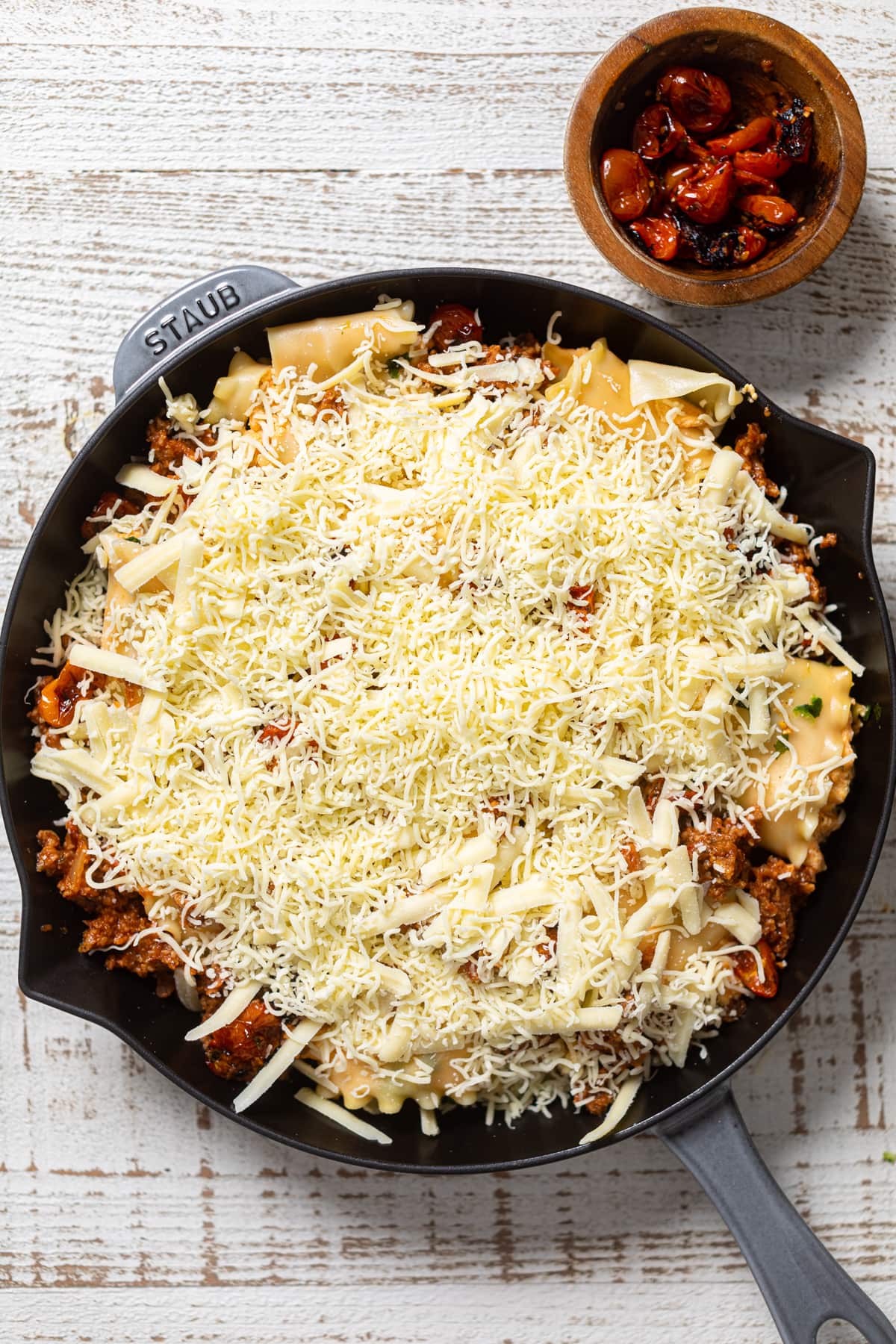 Meatless Pumpkin Lasagna ingredients in a skillet and topped with shredded cheese