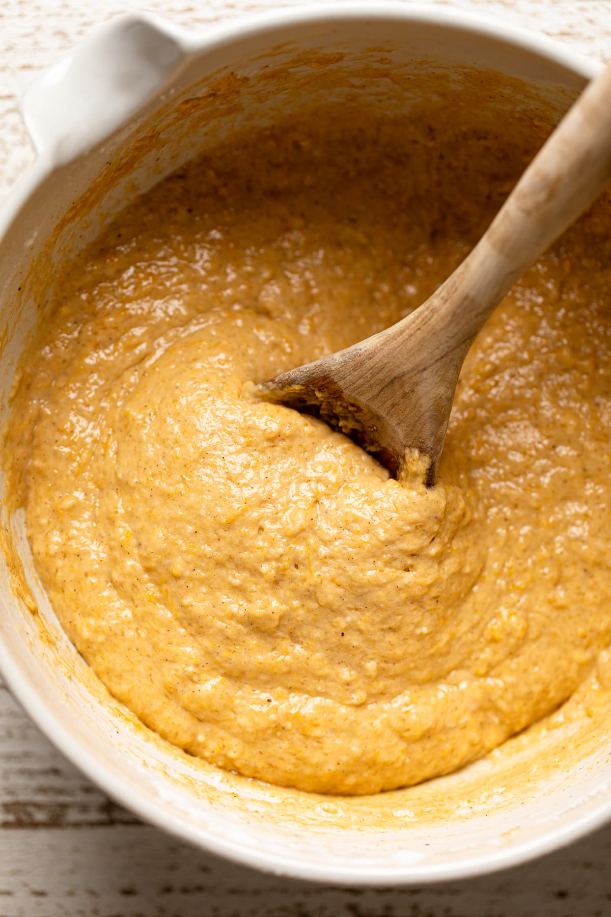 Wooden spoon stirring Vegan Sweet Potato Crumble Bread dough