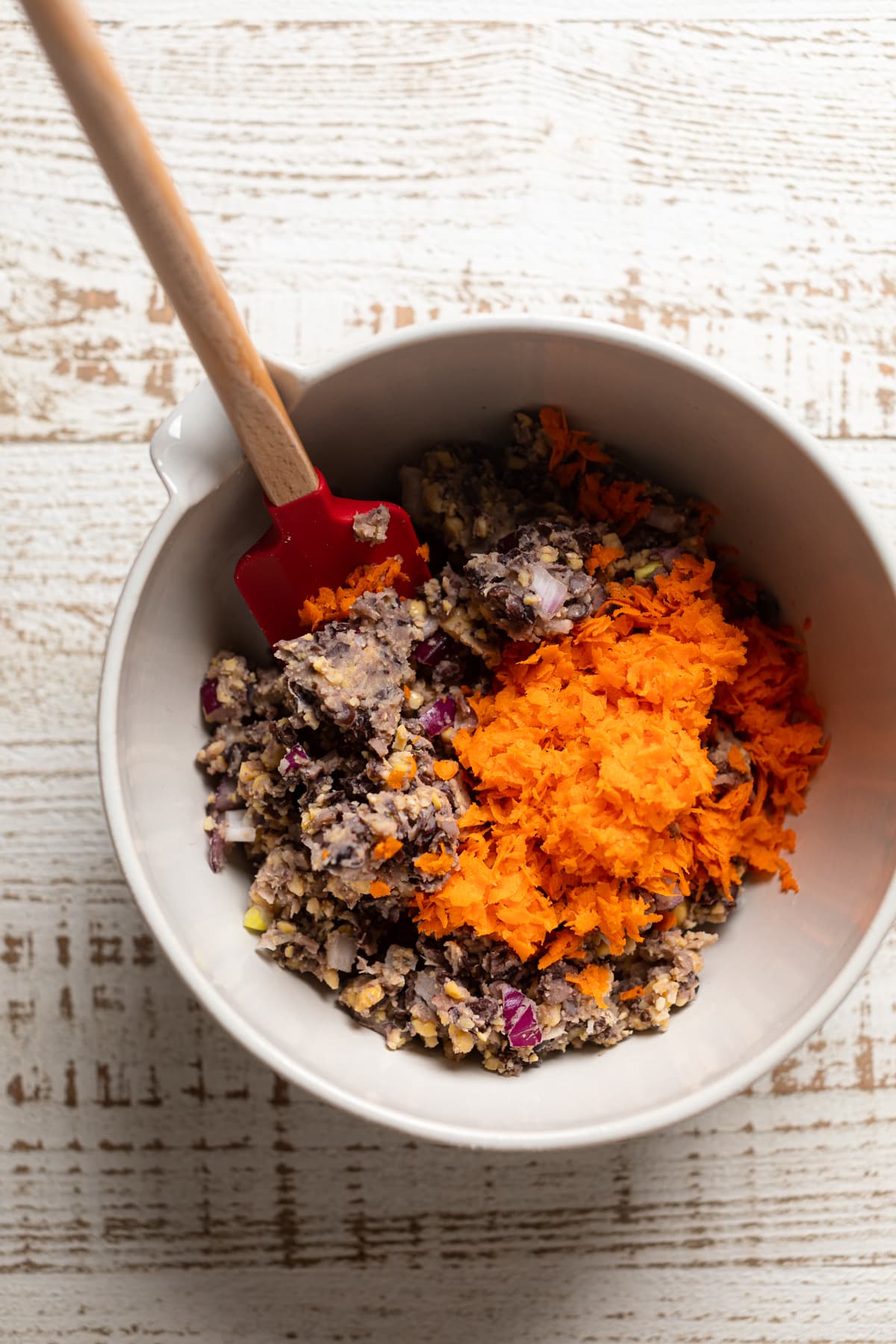 Bowl of barbeque wellington filling with a pile of shredded carrots on top