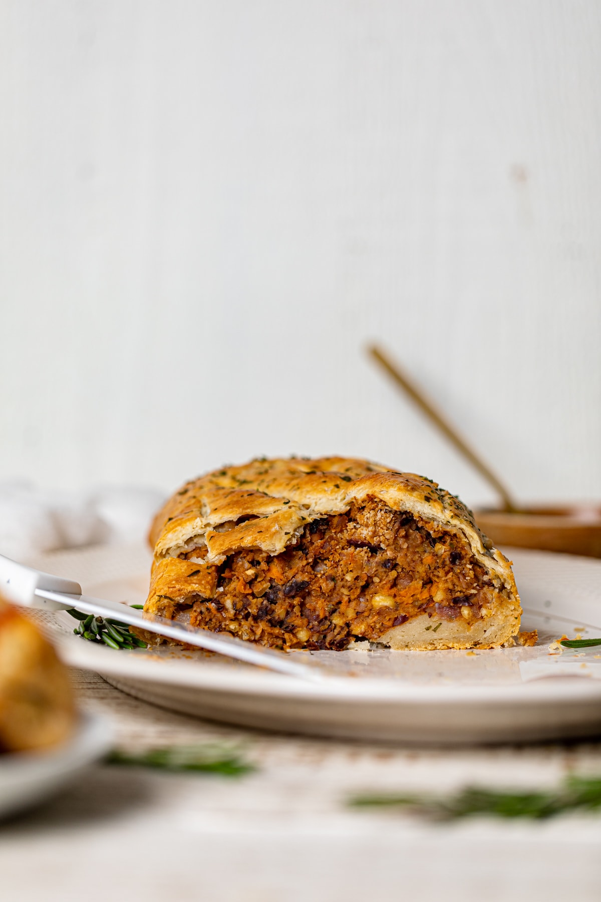 Partially-sliced Vegan BBQ Wellington on a white serving platter