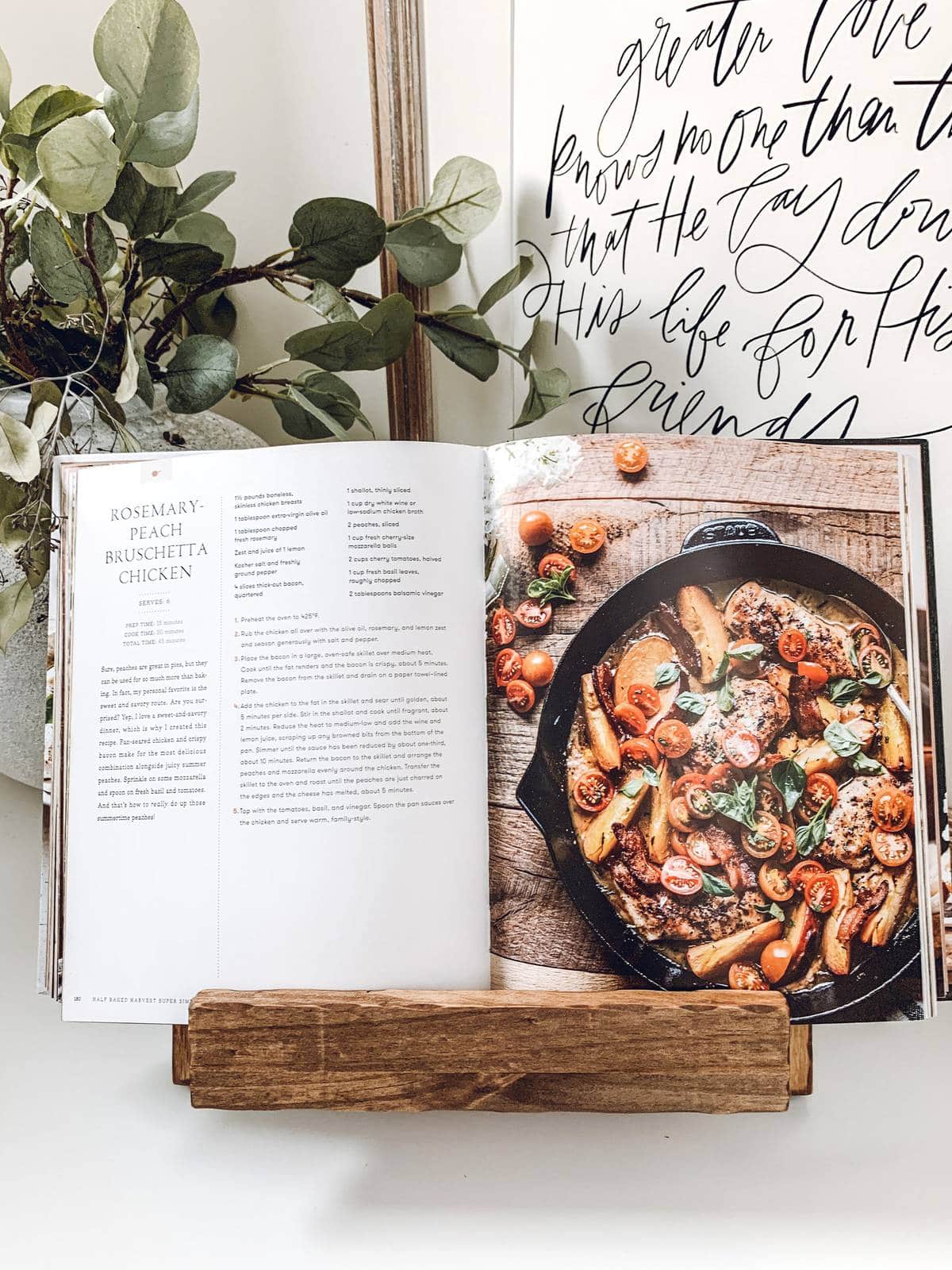 Cookbook held upright and open by a wooden stand