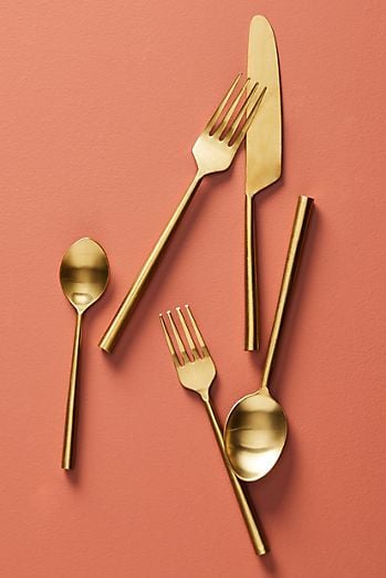 Golden silverware with two forks, two spoons, and a knife