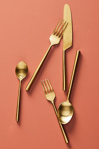 Golden silverware with two forks, two spoons, and a knife