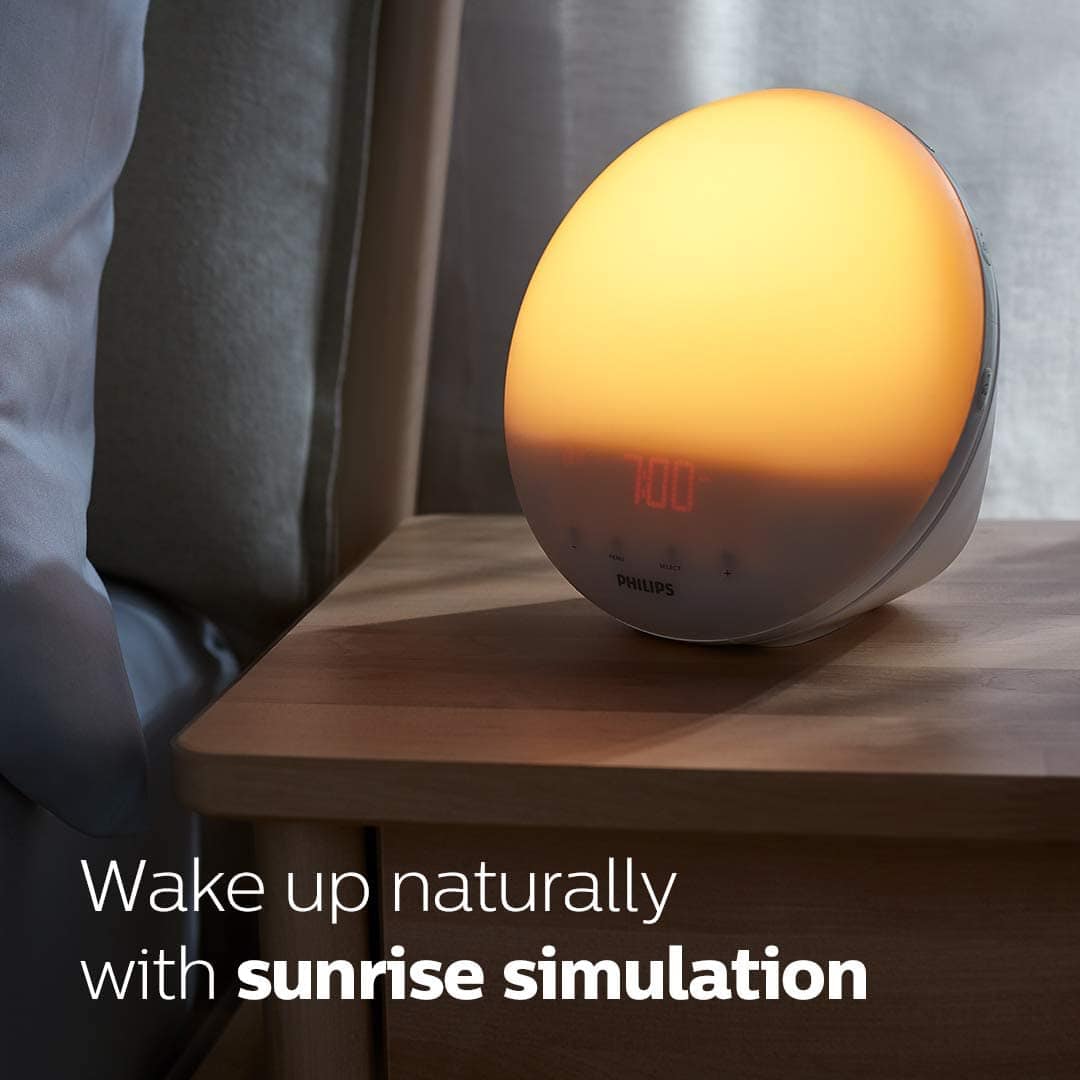 Yellow-lighted alarm clock with text \"Wake up naturally with sunrise simulation\"