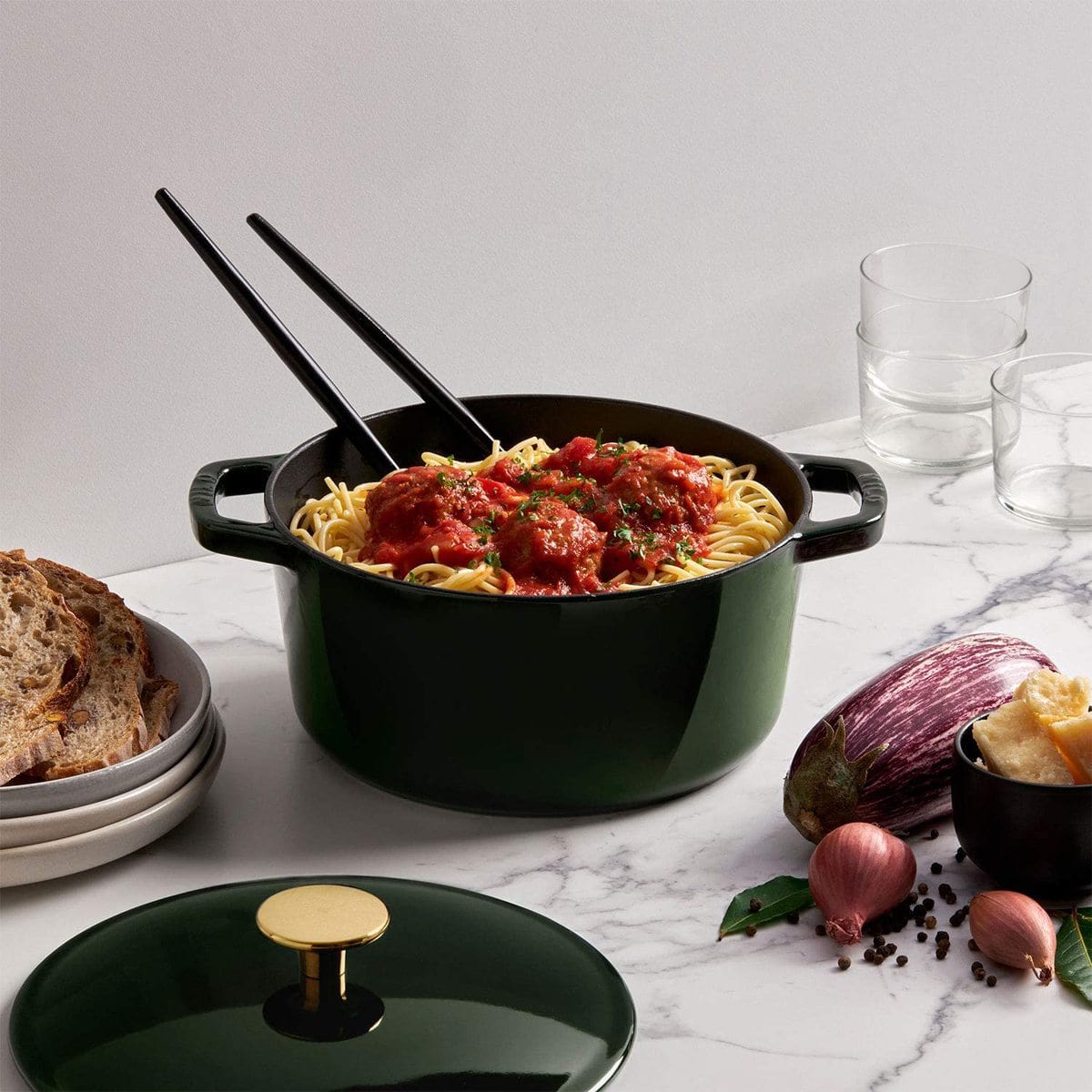 Green cast iron Dutch oven filled with spaghetti