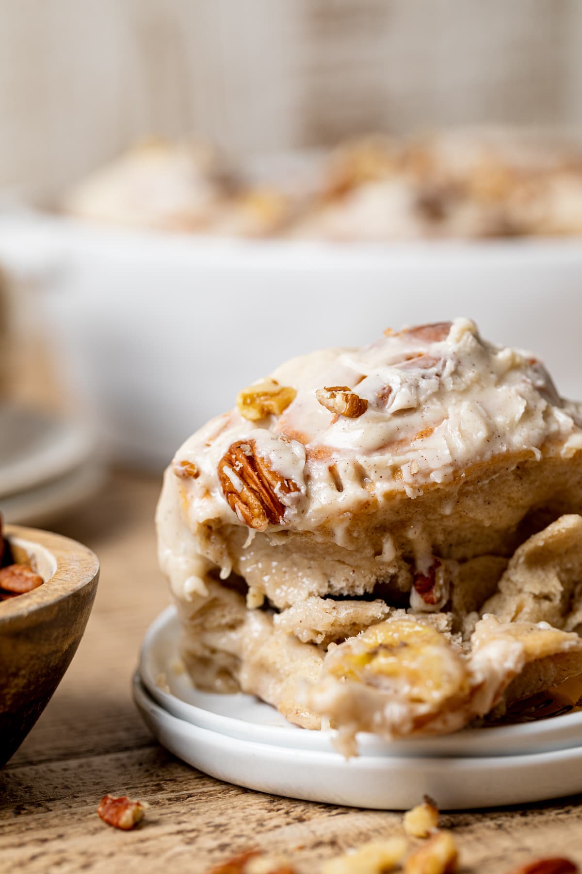 Closeup of a partially-eaten Banana Bread Cinnamon Roll with Maple Cream Cheese Frosting 