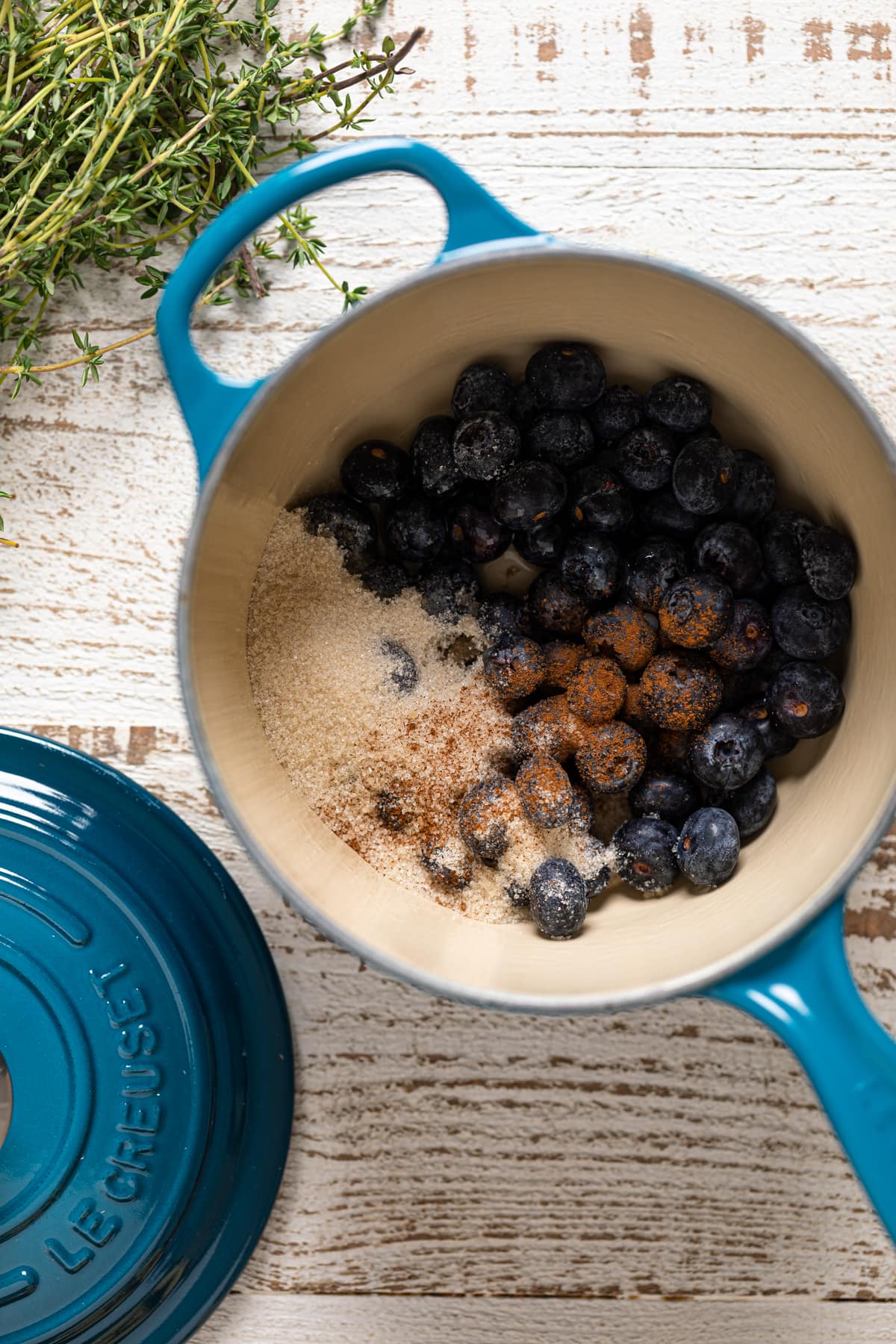 Blueberries and seasonings in a blue Le Creuset pan