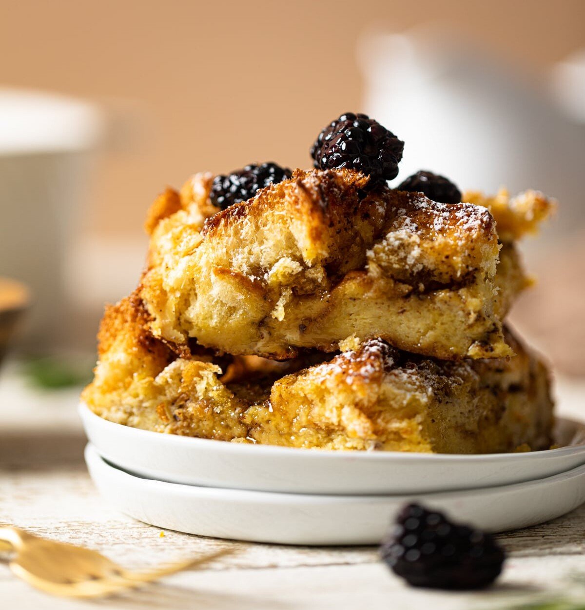 Pieces of Cinnamon Brown Butter French Toast Casserole on two small, stacked plates
