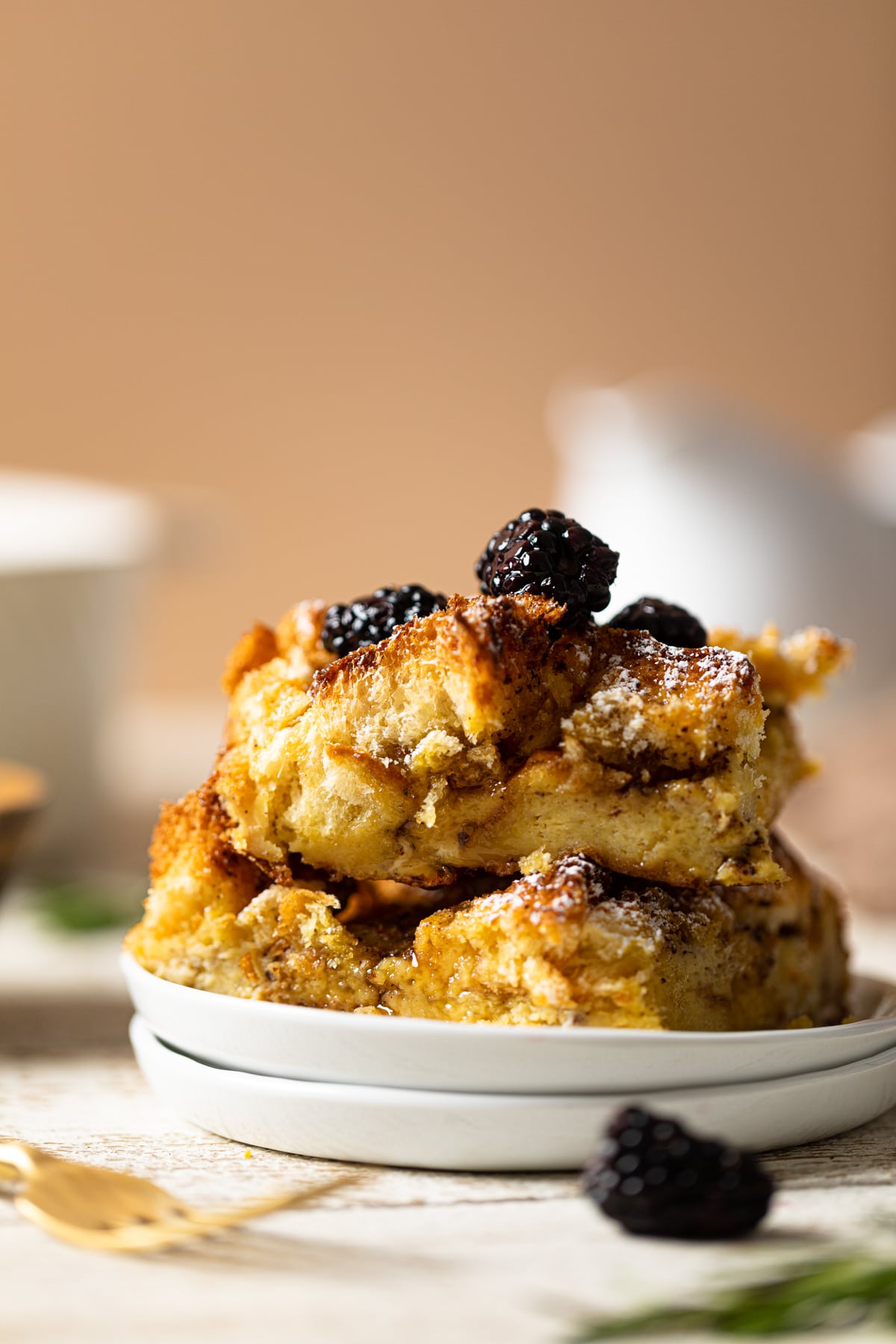 Pieces of Cinnamon Brown Butter French Toast Casserole on two small, stacked plates