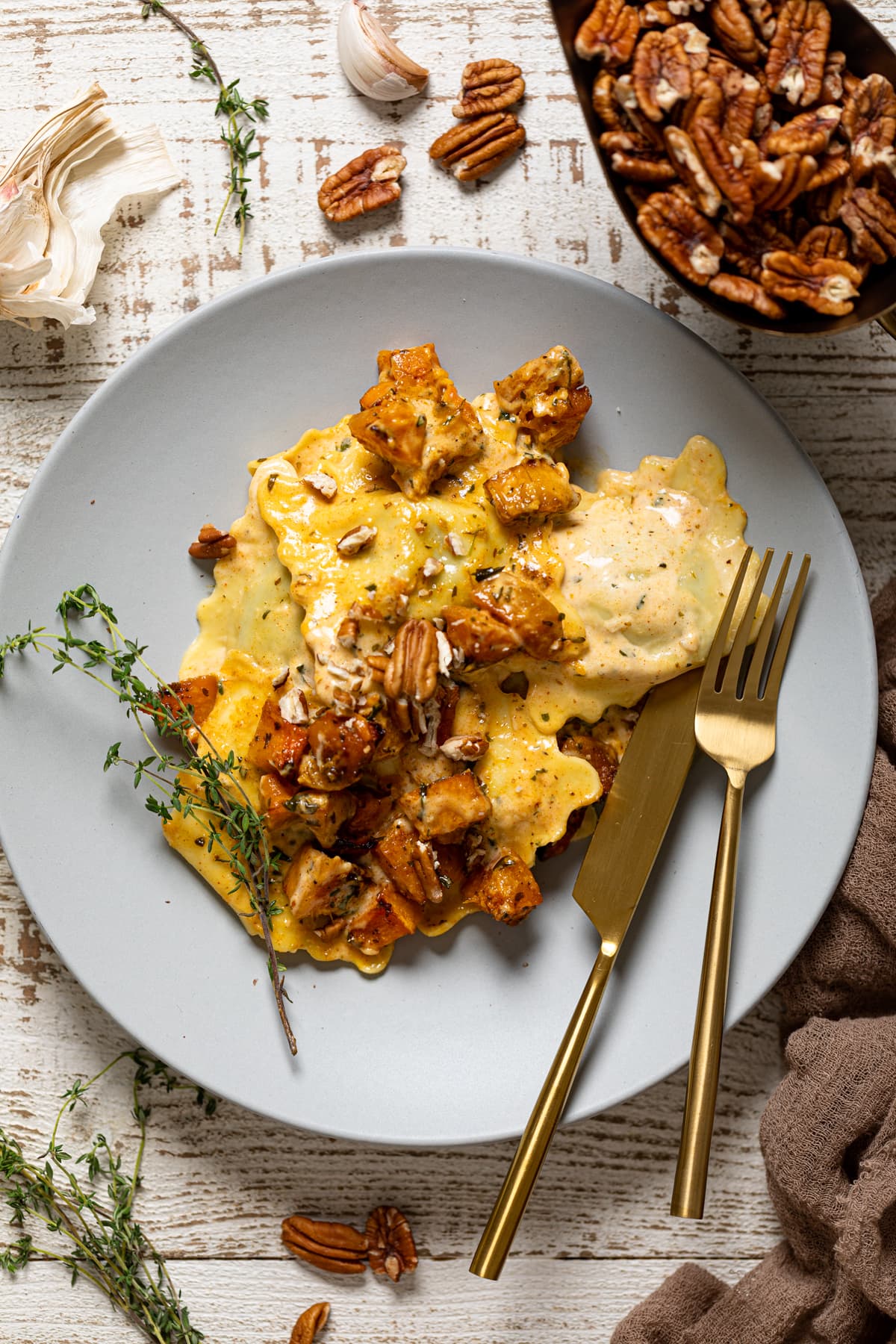 Fork and knife on a plate of Roasted Butternut Squash Pasta with Parmesan Garlic Sauce