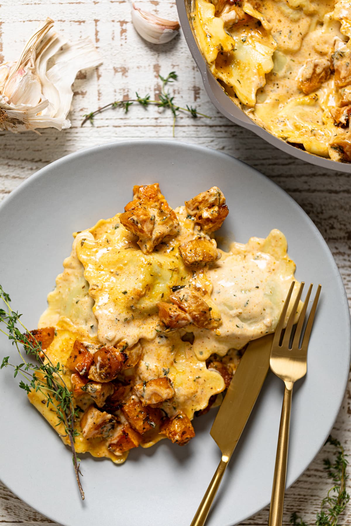 Fork and knife on a grey plate with Roasted Butternut Squash Pasta with Parmesan Garlic Sauce