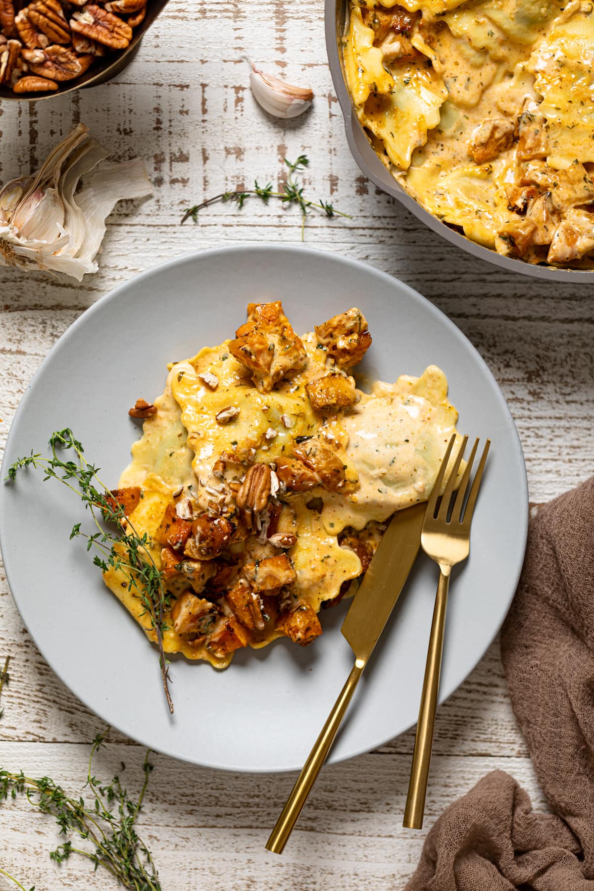 Fork and knife on a plate of Roasted Butternut Squash Pasta with Parmesan Garlic Sauce