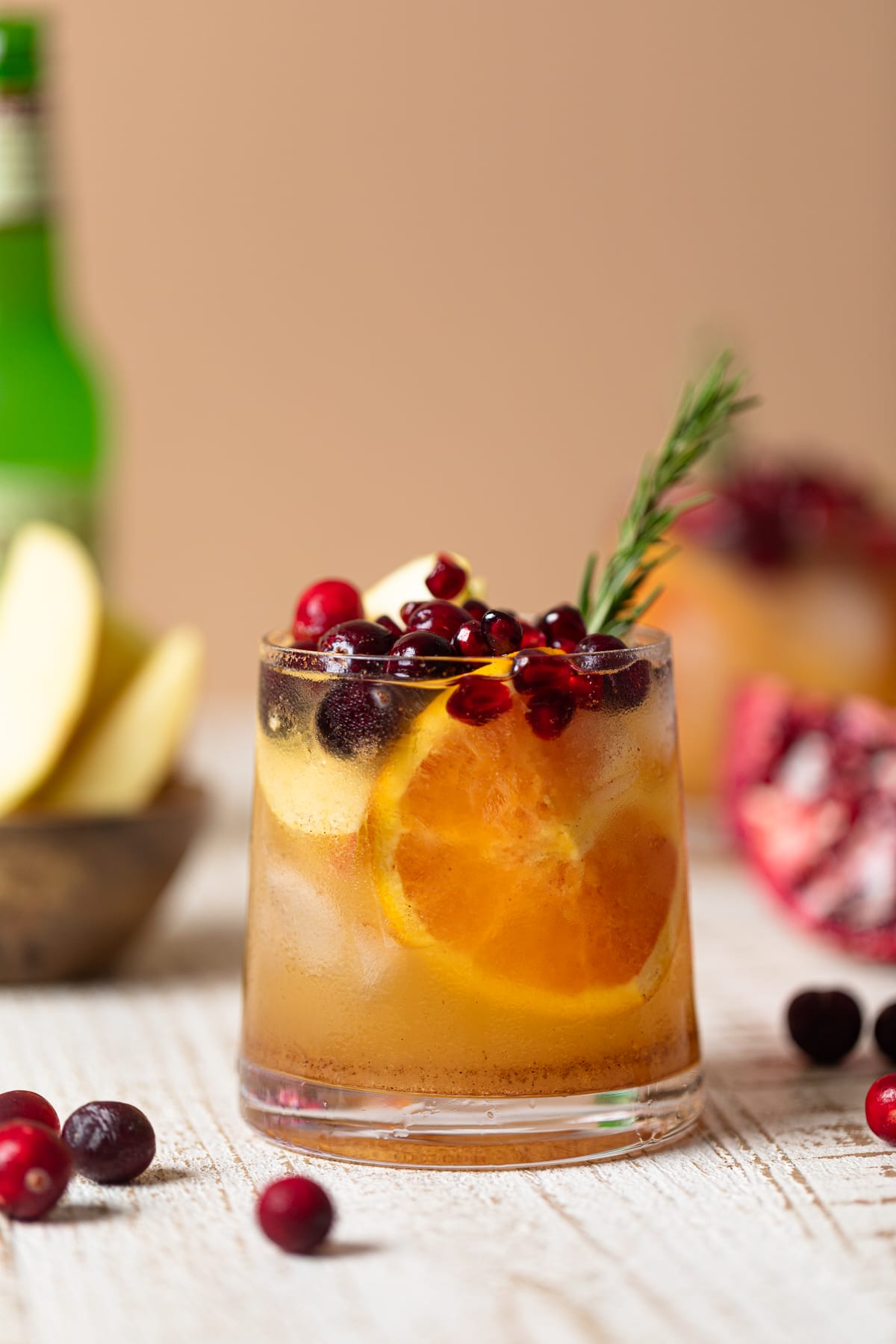 Thanksgiving Punch Mocktail topped with pomegranate arils, cranberries, and a rosemary sprig