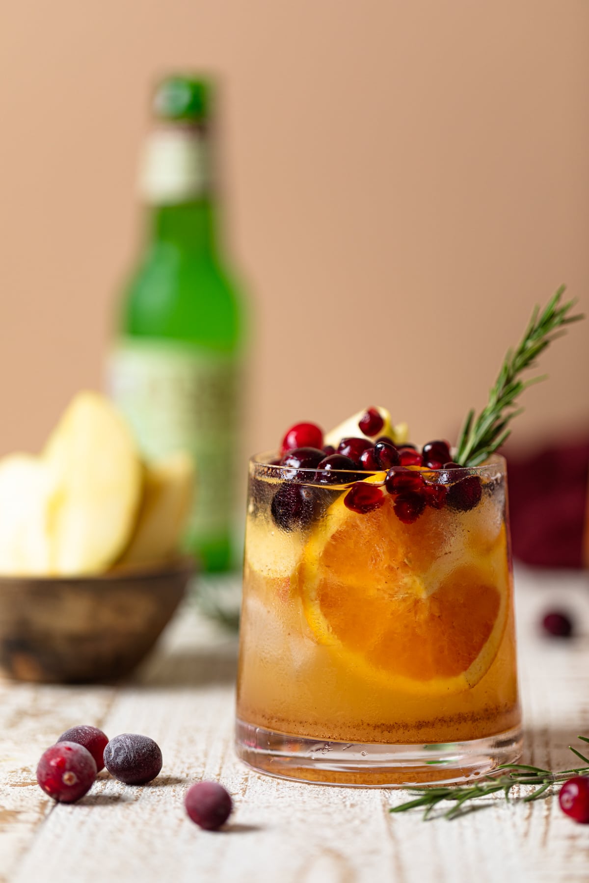 Thanksgiving Punch Mocktail topped with pomegranate arils, cranberries, and a rosemary sprig