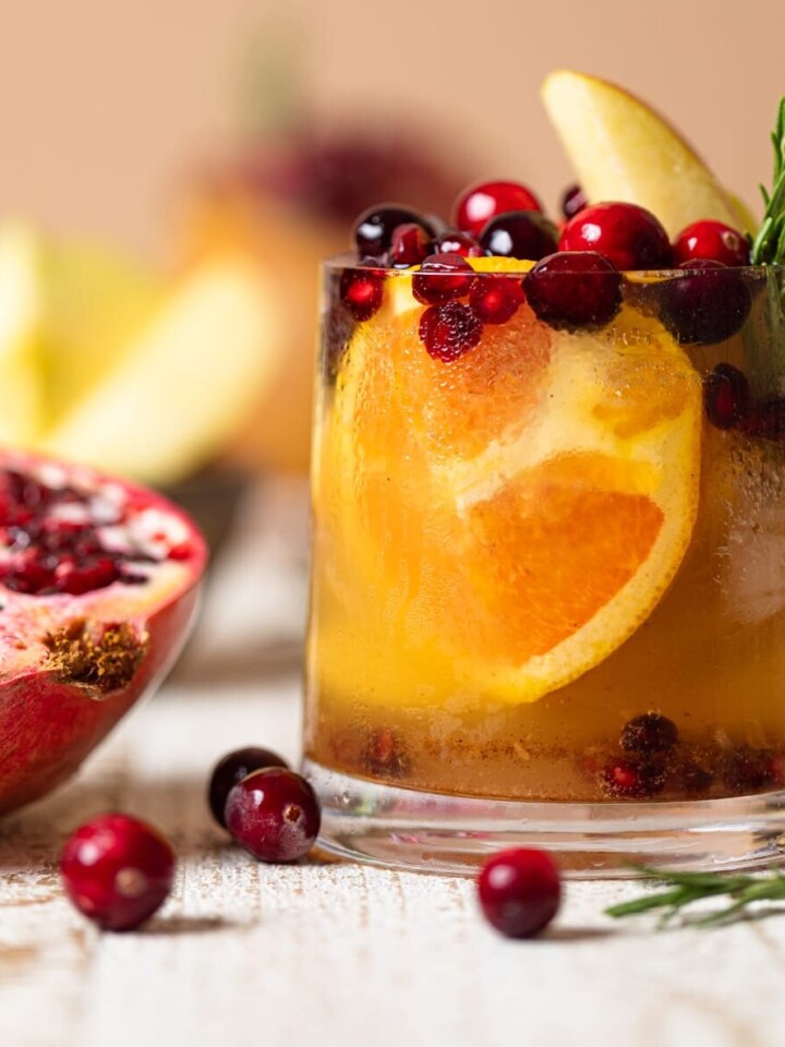 Thanksgiving Punch Mocktail next to a halved pomegranate