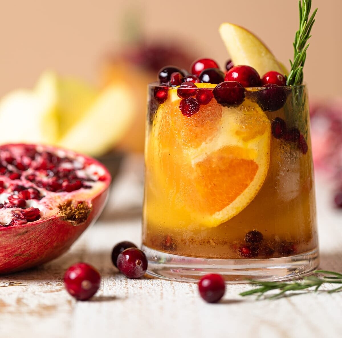 Thanksgiving Punch Mocktail next to a halved pomegranate