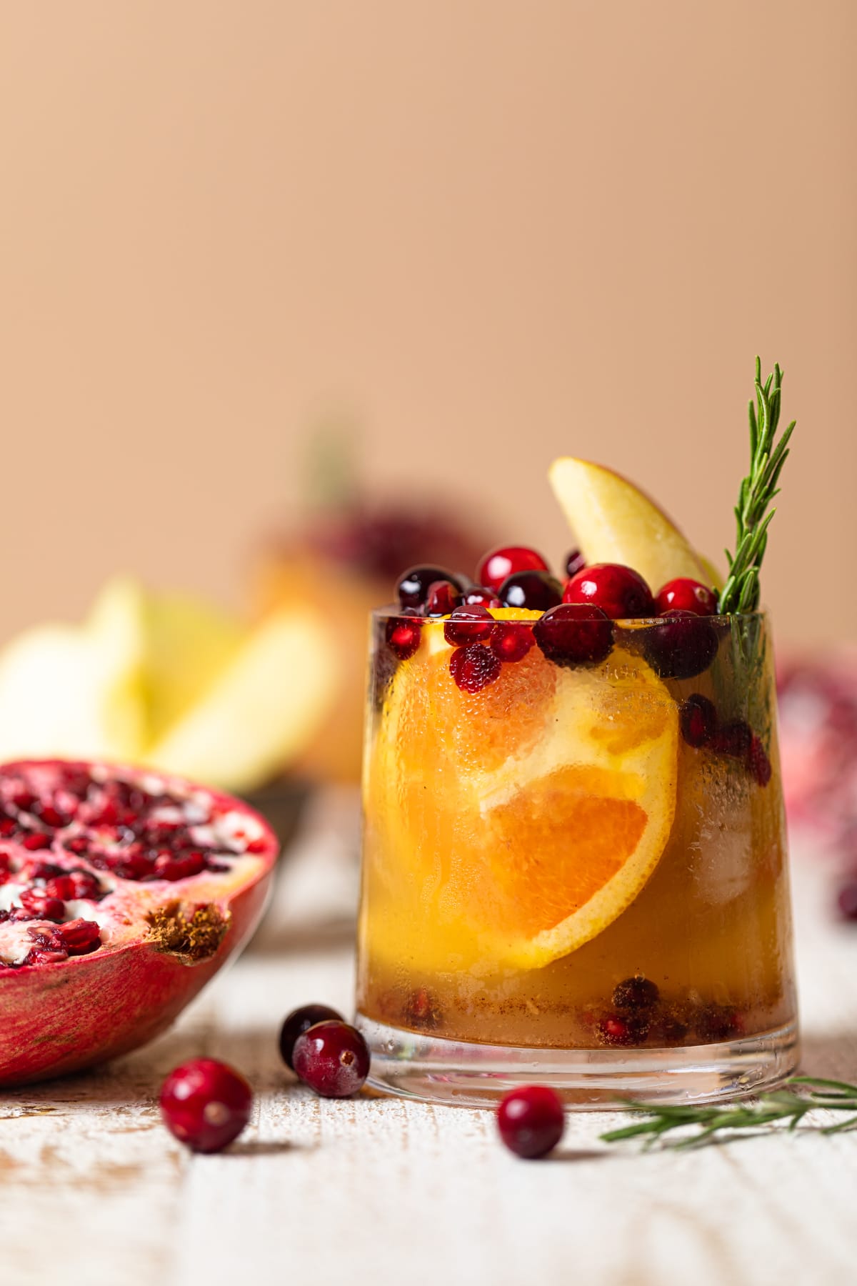 Thanksgiving Punch Mocktail next to a halved pomegranate