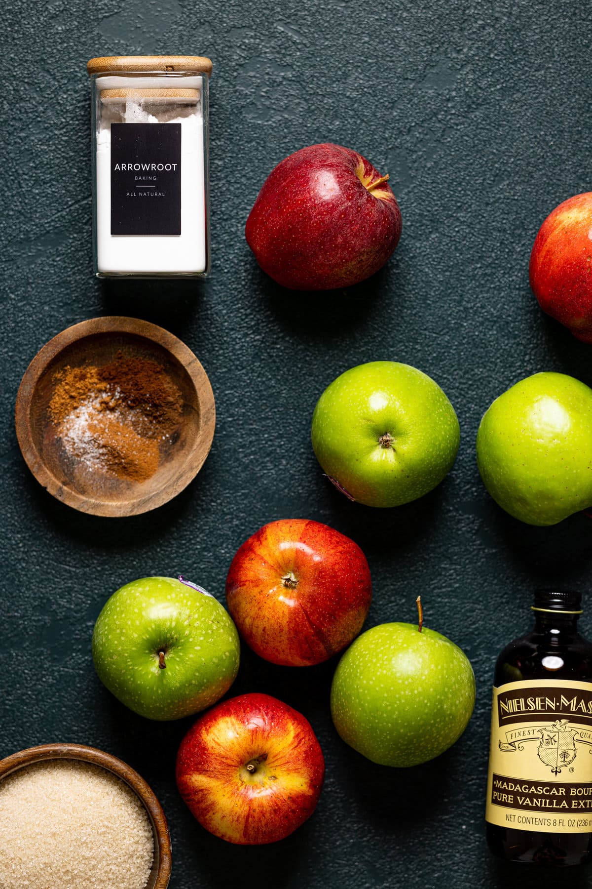 Ingredients for Dutch Apple Pie including red and green apples, vanilla extract, and arrowroot