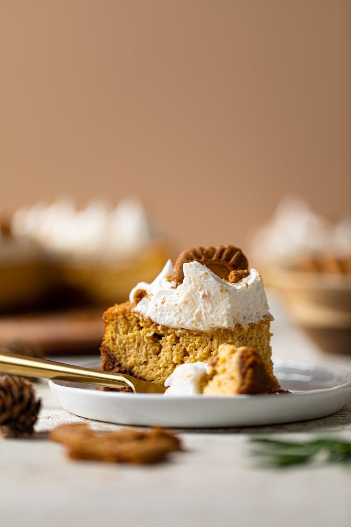 Fork and a slice of Pumpkin Cheesecake topped with a Biscoff Cookie. The best holiday dessert