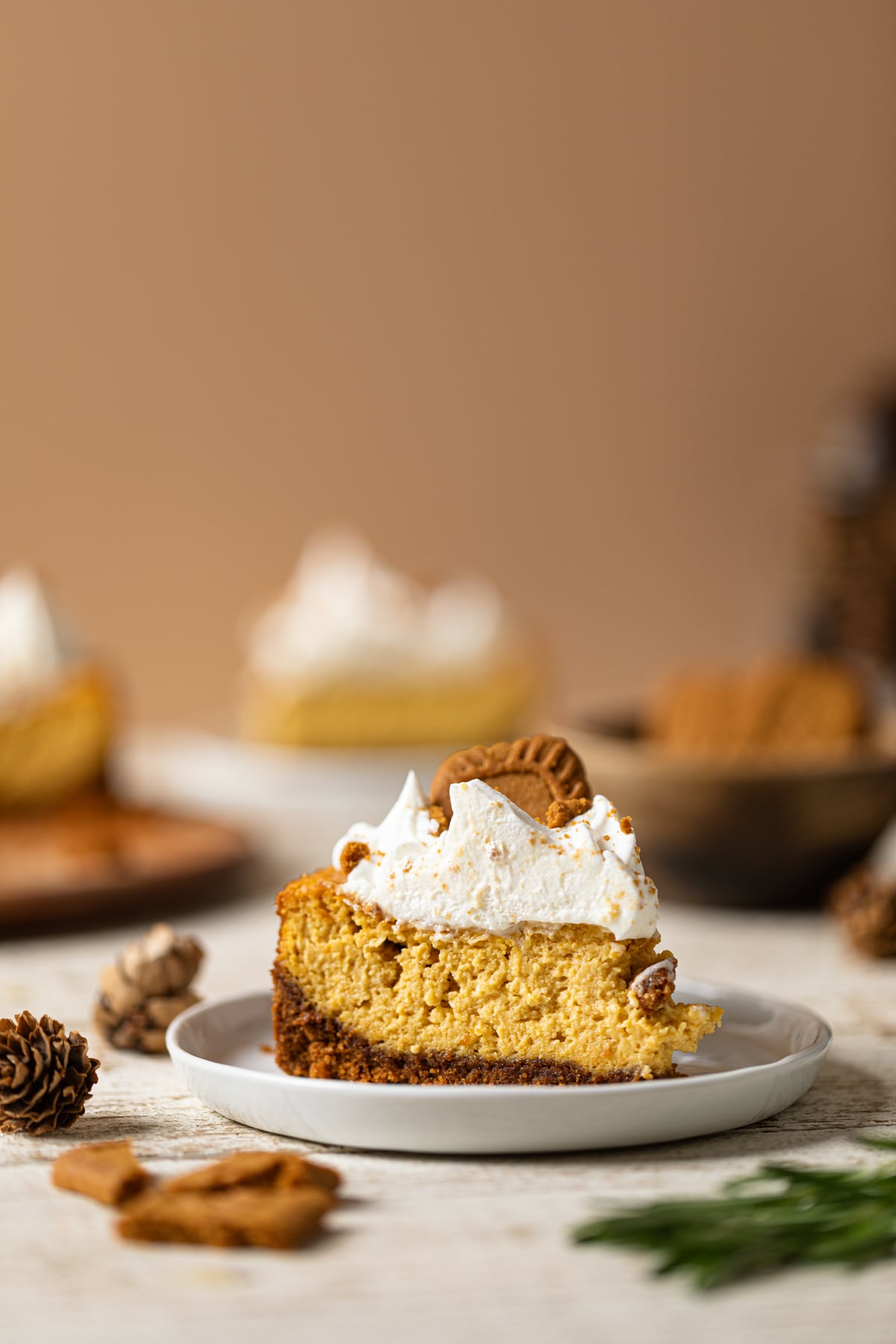 Slice of Pumpkin Cheesecake topped with a Biscoff Cookie