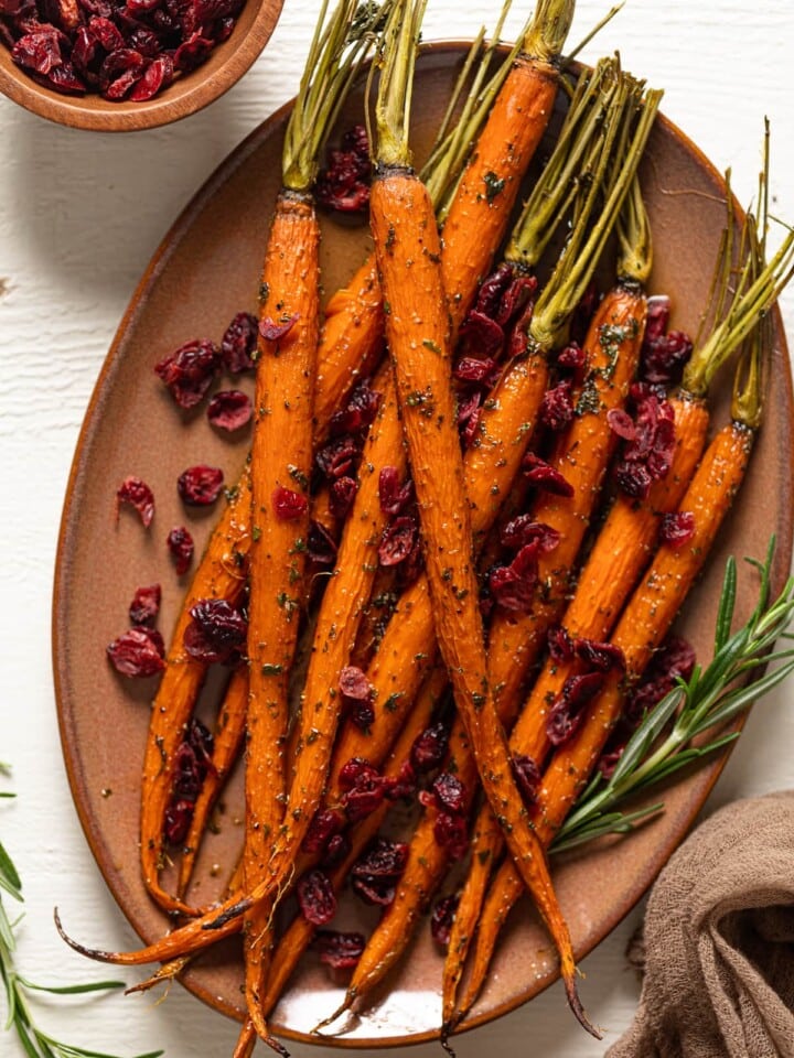 Maple Herb Glazed Carrots and Cranberries on a light brown serving platter