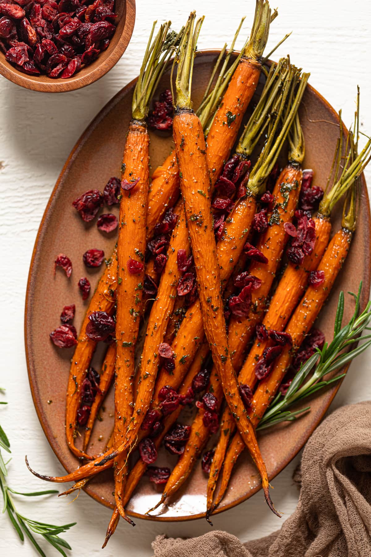 Maple Herb Glazed Carrots and Cranberries on a light brown serving platter