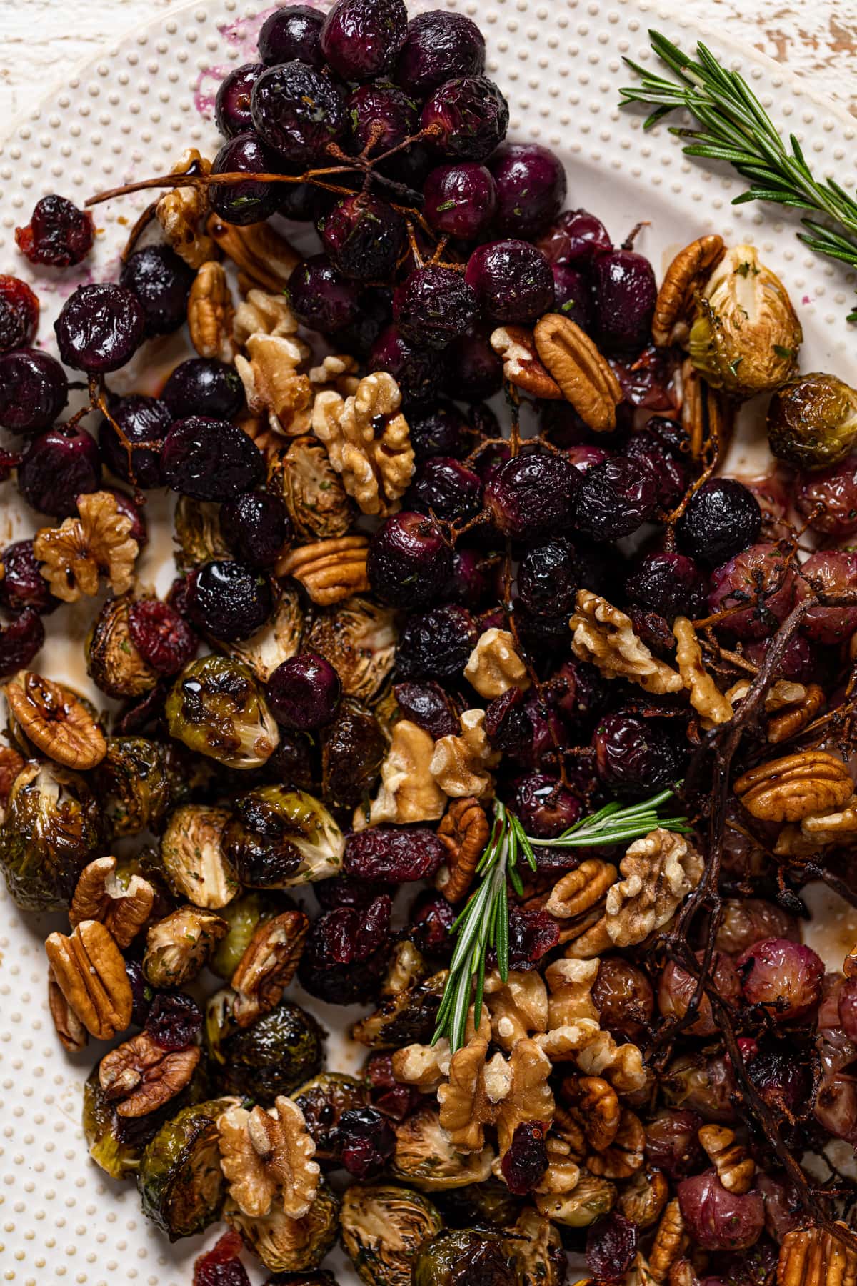 Closeup of Roasted Grapes and Brussels Sprouts on a white serving platter