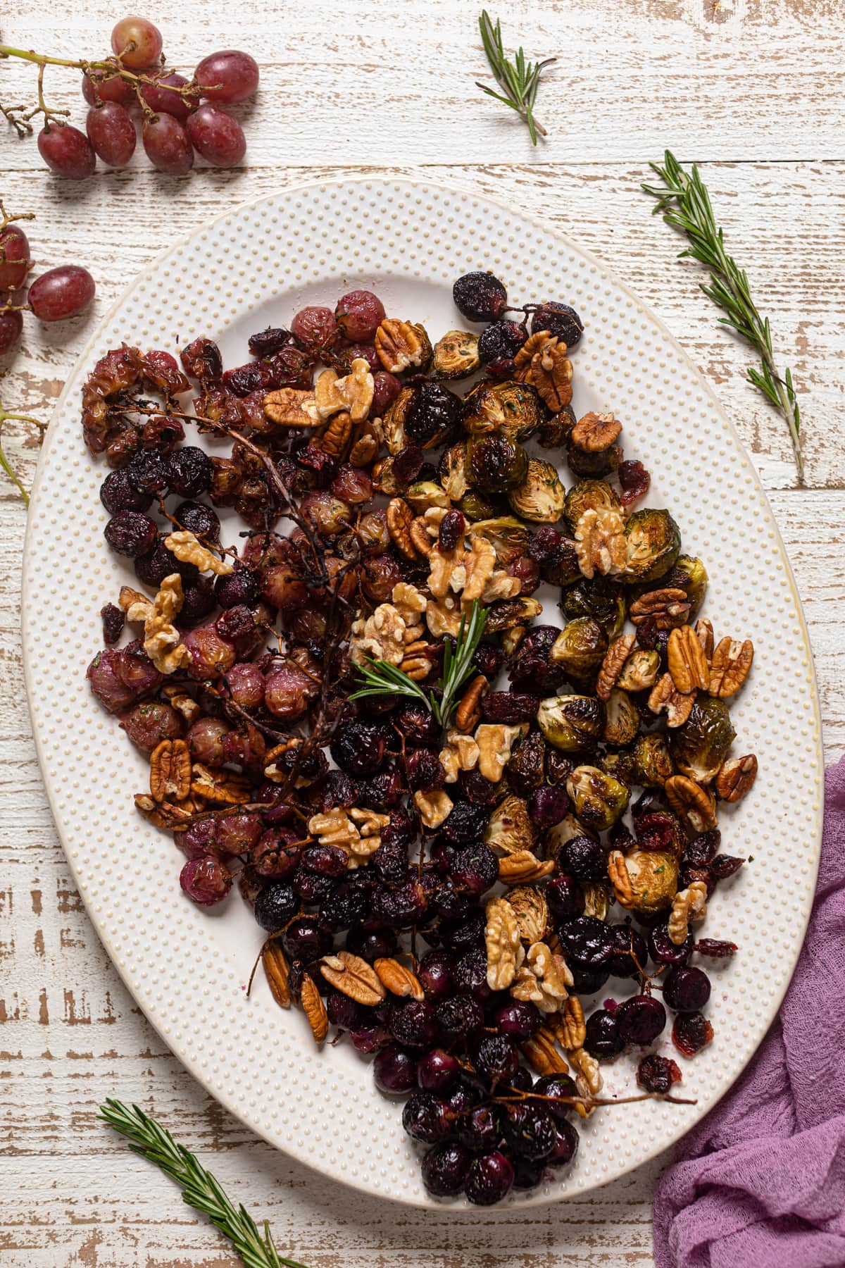 Overhead shot of Roasted Grapes and Brussels Sprouts on a white serving platter