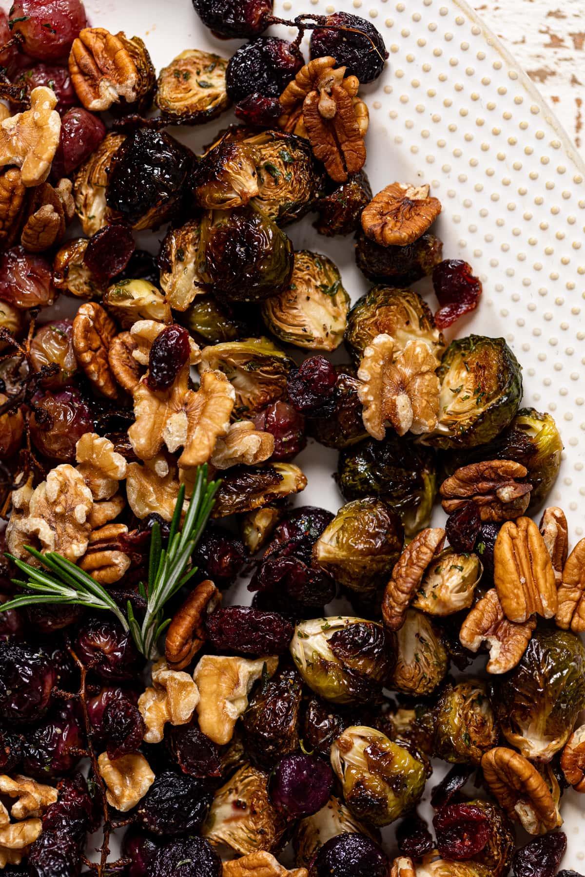 Closeup of Roasted Grapes and Brussels Sprouts on a white serving platter