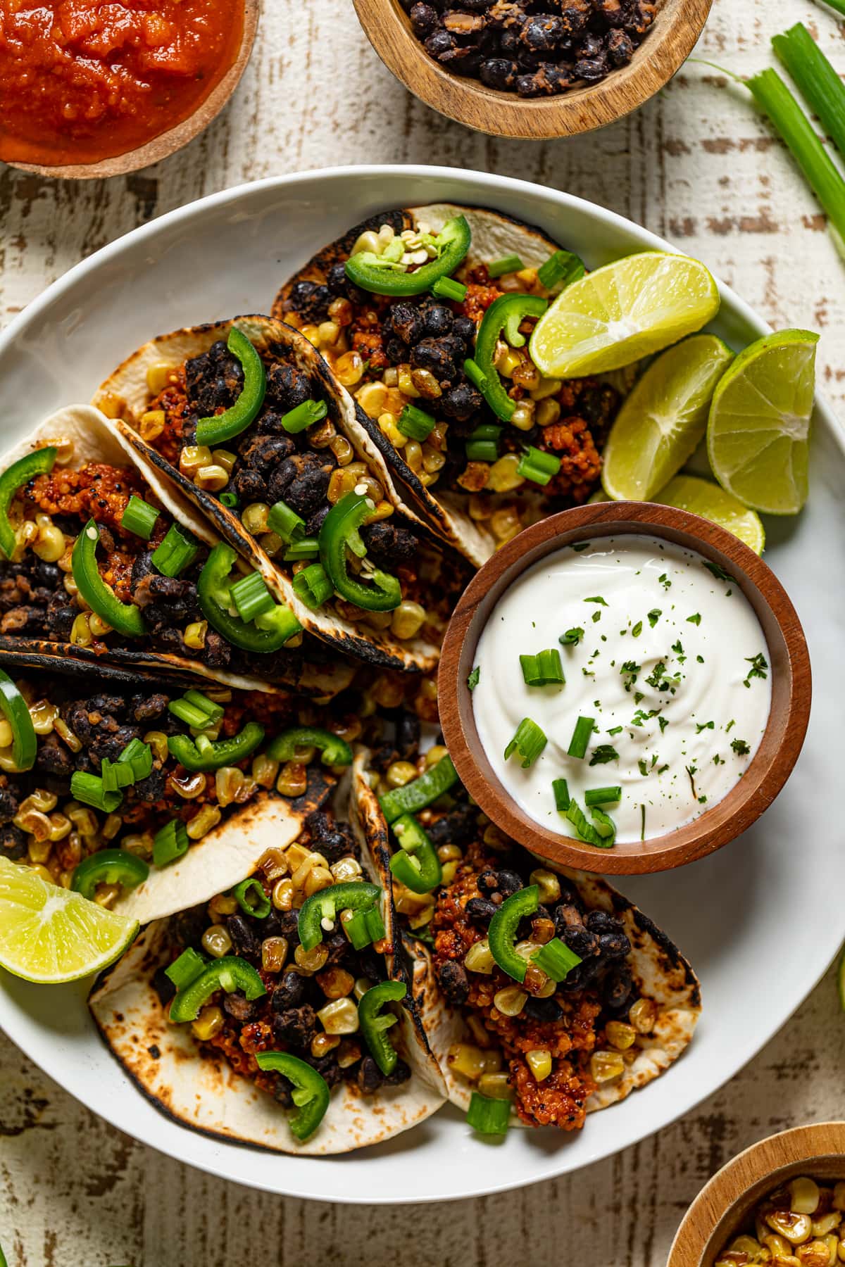 Overhead shot of a plate of Spicy Sofritas Quinoa Tacos with lime sour cream