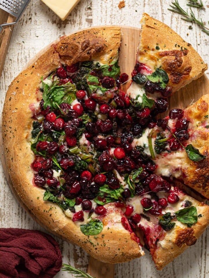 Partially-sliced Thanksgiving Pizza on a wooden board