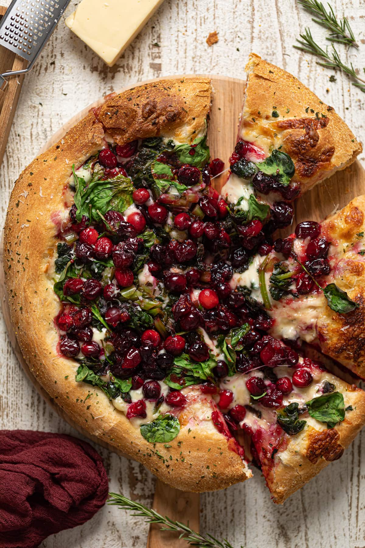 Partially-sliced Thanksgiving Pizza on a wooden board