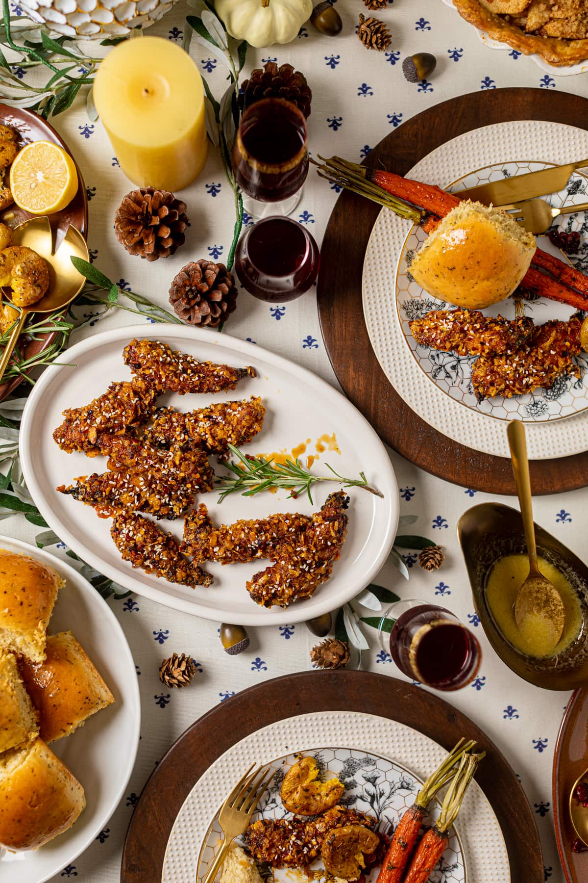 Closeup of a table set with serving dishes of food, fall decorations, and plates with various foods