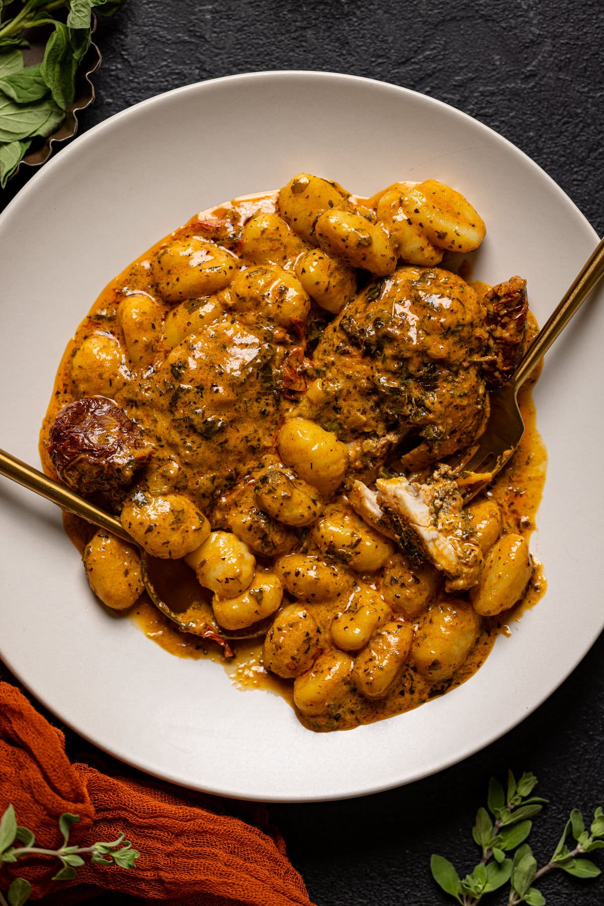 Plate of Creamy Tuscan 'Marry Me' Chicken with silverware. Vegan pasta option.