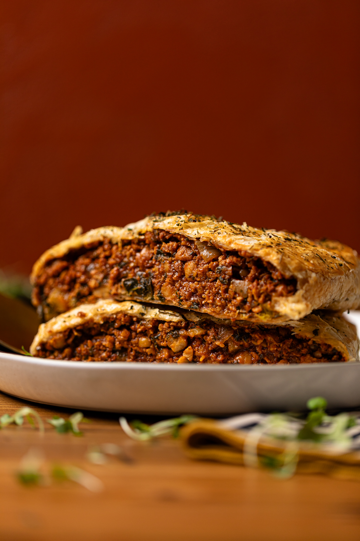 Image of sliced vegan Wellington stacked on each other on a plate.