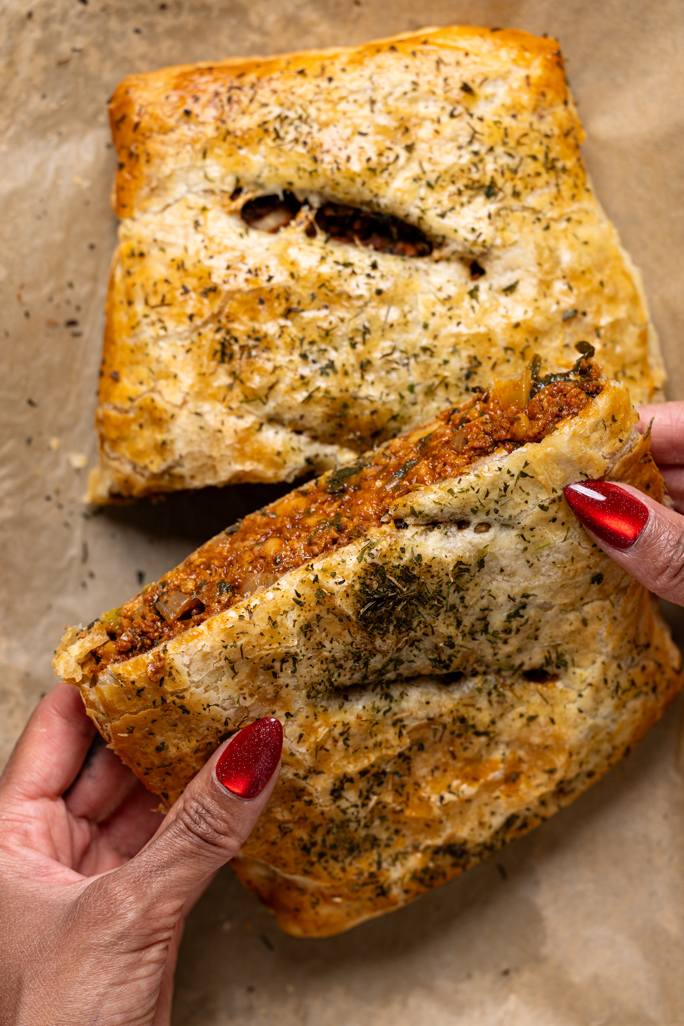 Image of vegan Wellington sliced and held by woman hands.