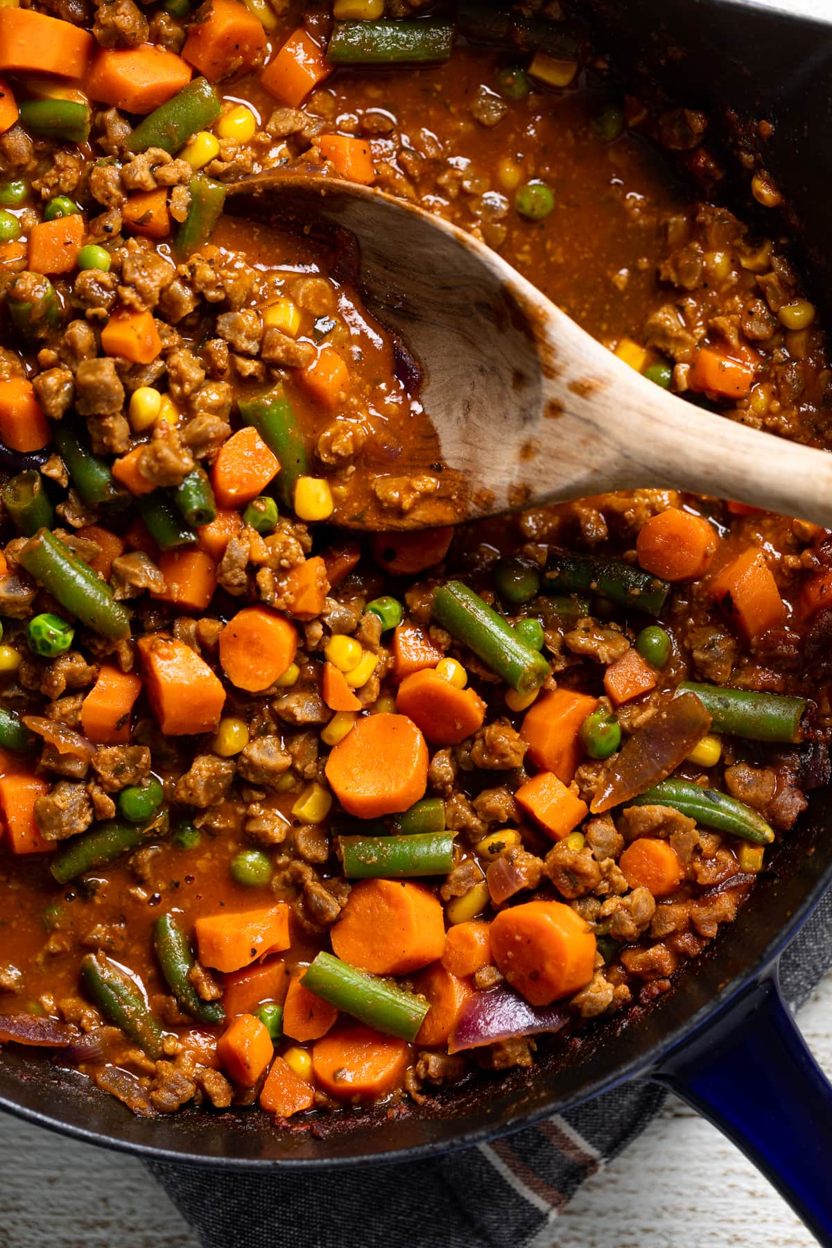 Wooden spoon stirring Butternut Squash Sweet Potato Shepherd’s Pie filling