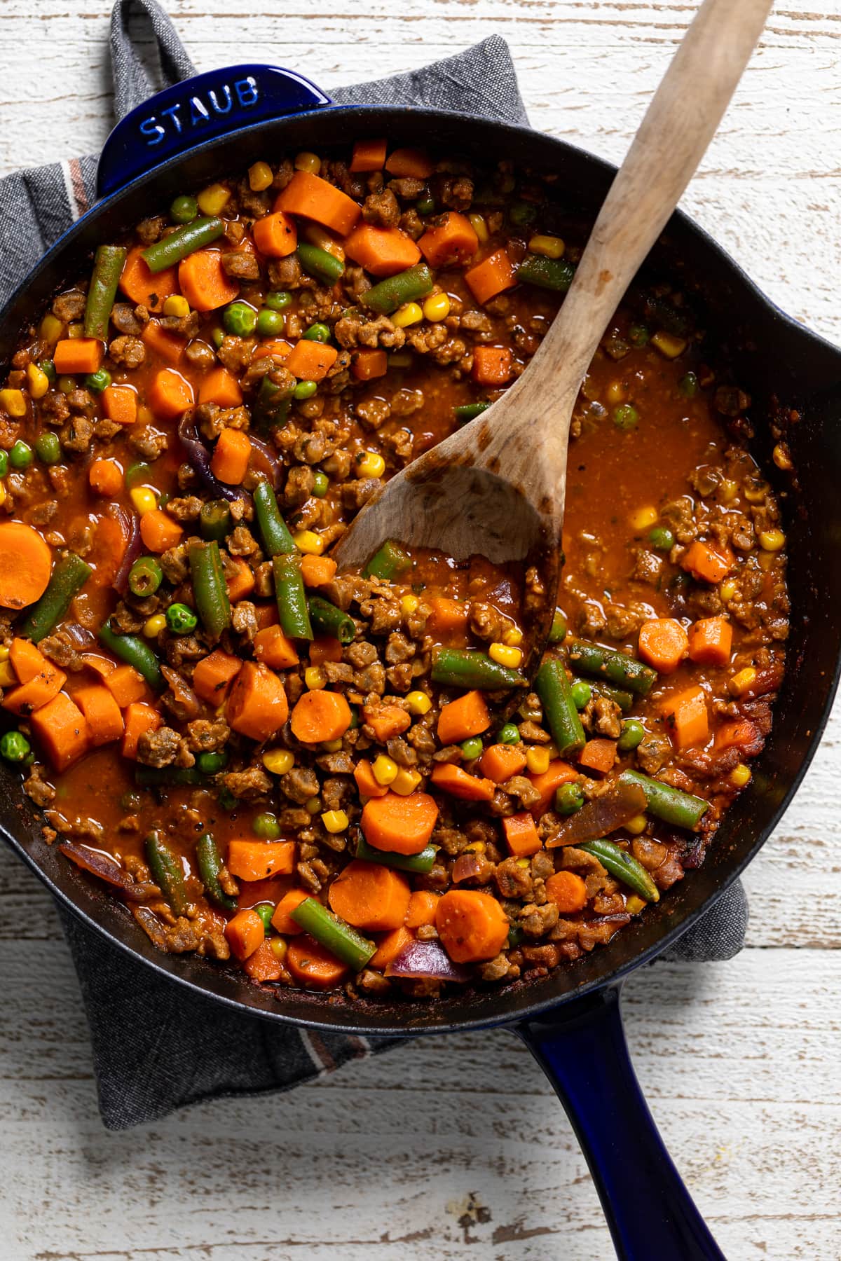Wooden spoon stirring Butternut Squash Sweet Potato Shepherd’s Pie filling