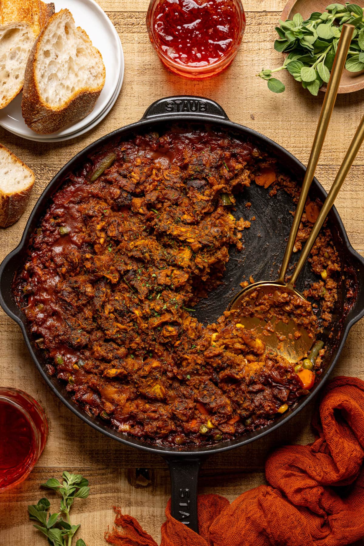 Shepherd's pie scooped out of skillet with two gold forks, side of drink + bread.