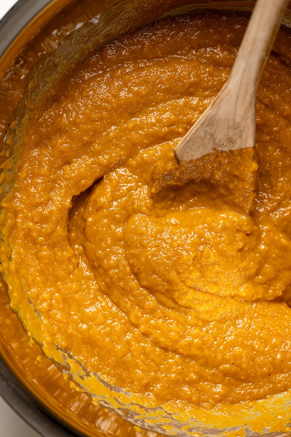 Wooden spoon stirring sweet potato pie filling