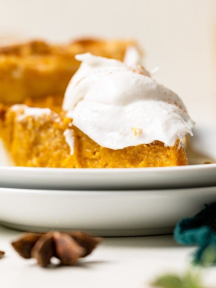 Slice of Vegan Sweet Potato Pie topped with coconut whipped cream