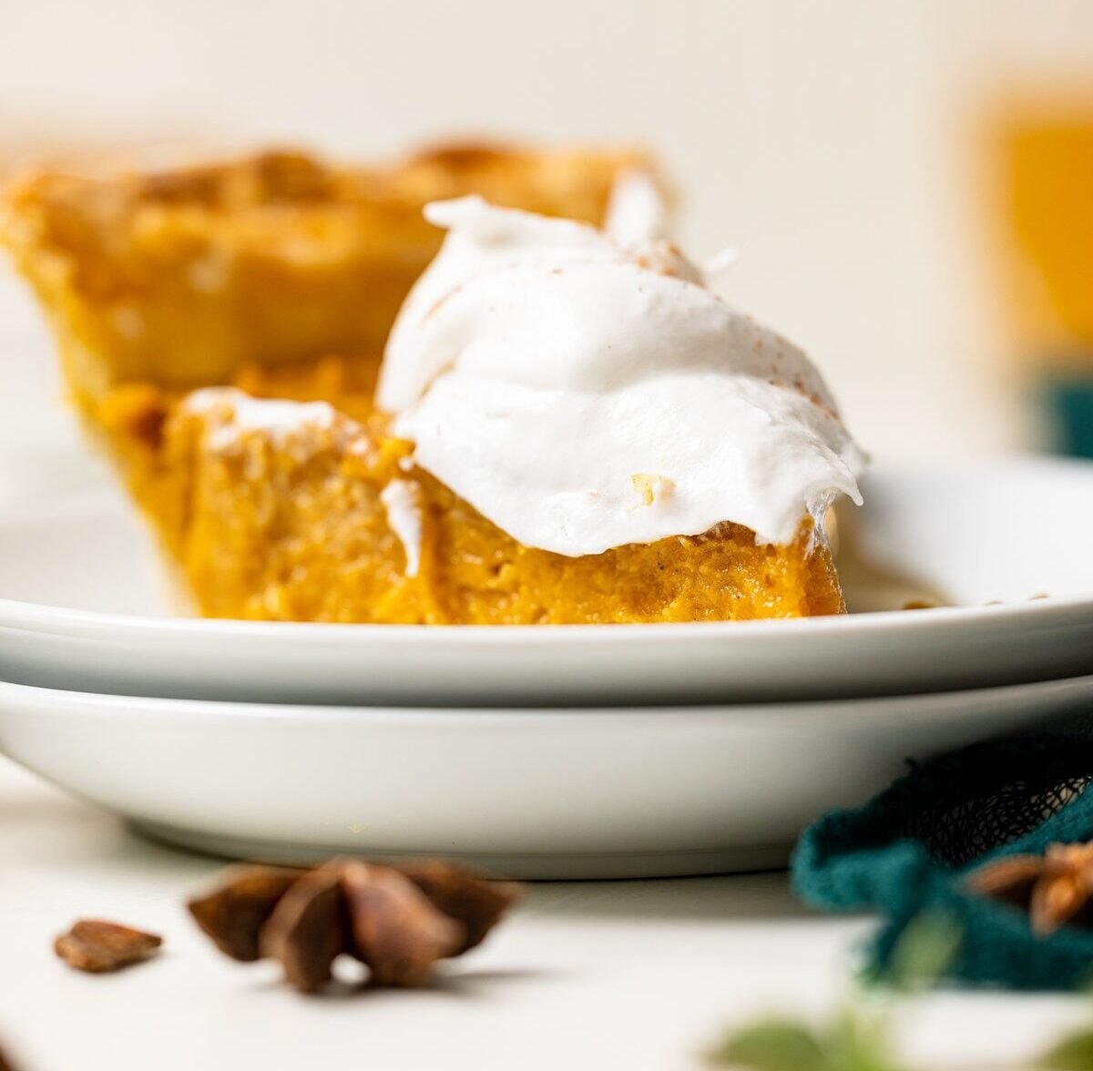 Slice of plant-based Sweet Potato Pie topped with coconut whipped cream